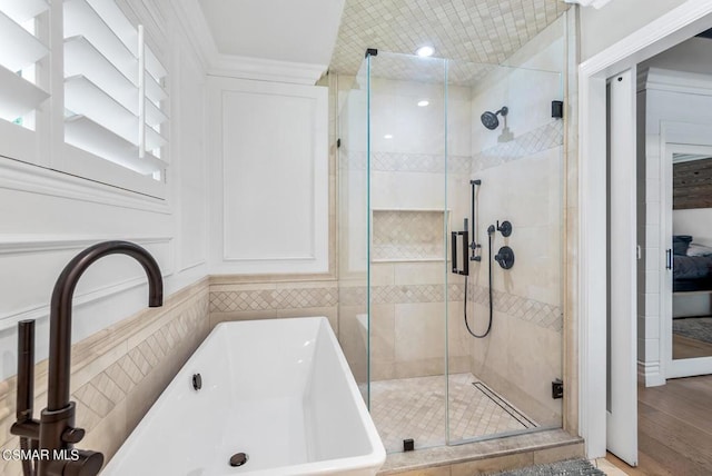 bathroom with shower with separate bathtub, sink, and hardwood / wood-style floors