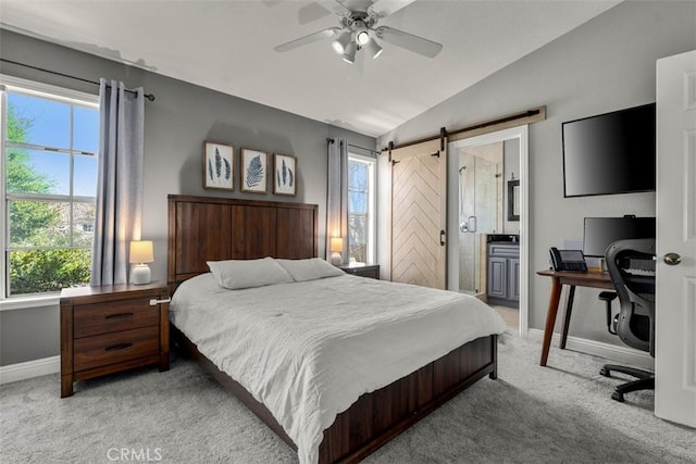 bedroom with light colored carpet, a barn door, vaulted ceiling, and multiple windows