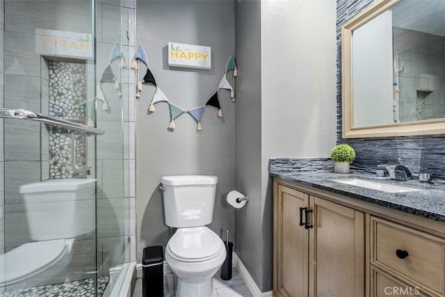 bathroom with vanity, toilet, a shower with door, and backsplash