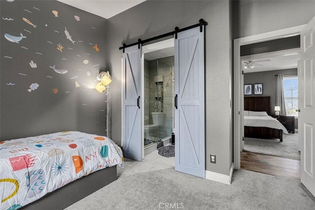 bedroom featuring a barn door and light carpet