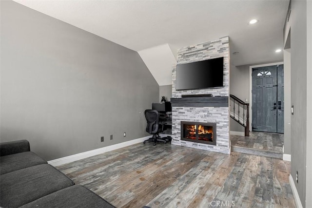 living room with a large fireplace and wood-type flooring