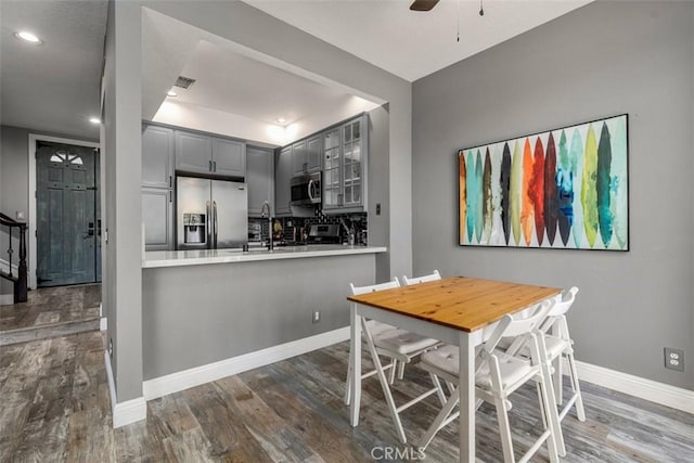 dining room featuring ceiling fan, sink, and hardwood / wood-style floors