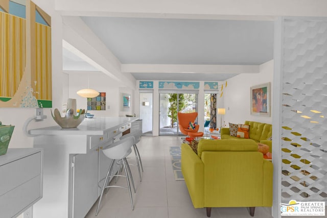 living room with beam ceiling and light tile patterned floors