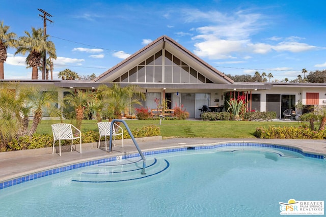 view of swimming pool with a yard and a patio