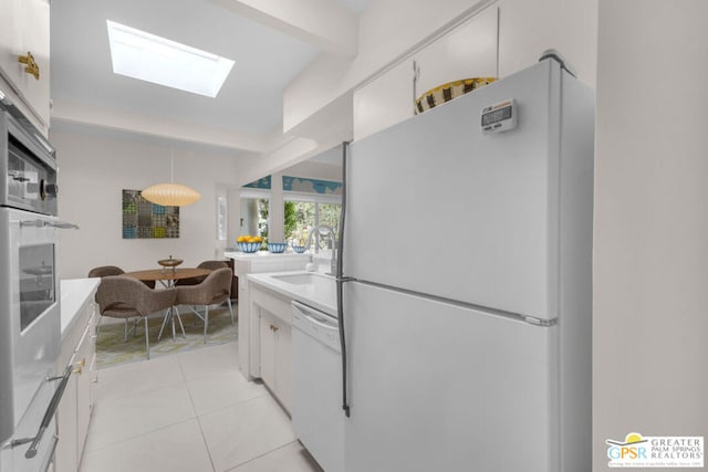 kitchen featuring pendant lighting, sink, white appliances, and white cabinets