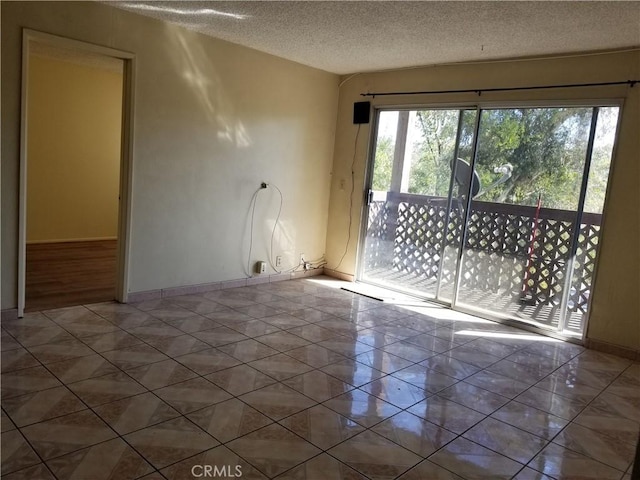 tiled empty room with a textured ceiling