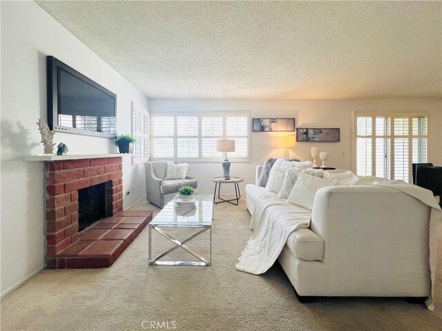 carpeted living room with a healthy amount of sunlight, a fireplace, and a textured ceiling