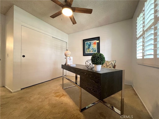 office area featuring ceiling fan, carpet floors, and a textured ceiling