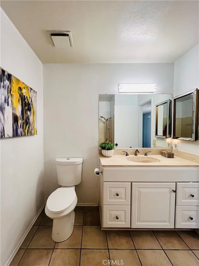 bathroom with vanity, a shower, tile patterned floors, and toilet