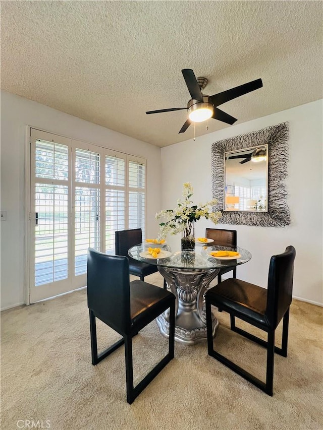 carpeted dining area featuring a textured ceiling