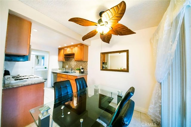 tiled dining room featuring sink, a textured ceiling, and ceiling fan