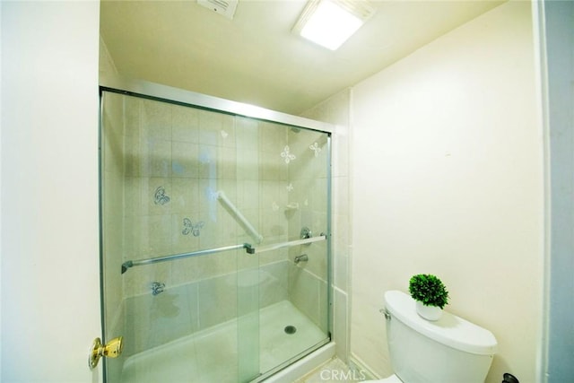 bathroom featuring toilet and an enclosed shower