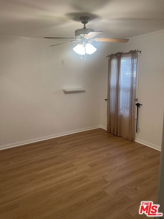 spare room featuring ceiling fan, ornamental molding, and dark hardwood / wood-style flooring