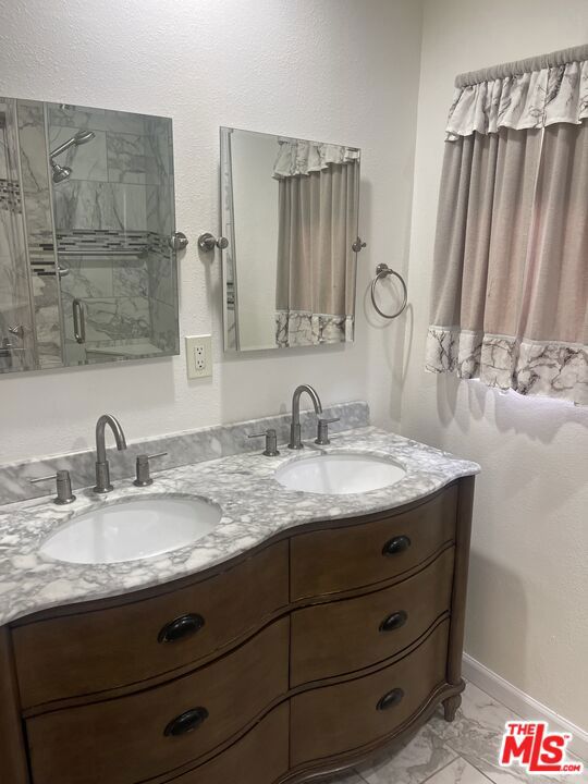 bathroom with walk in shower and vanity