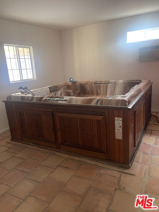 kitchen with a wall mounted AC and dark brown cabinetry