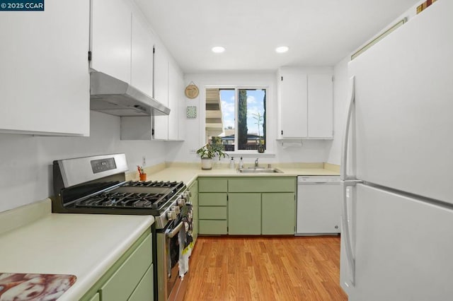 kitchen with sink, white appliances, light hardwood / wood-style floors, and green cabinets