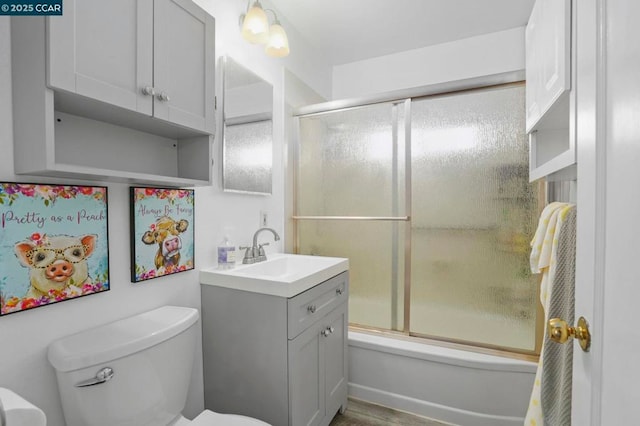 full bathroom with toilet, vanity, and bath / shower combo with glass door