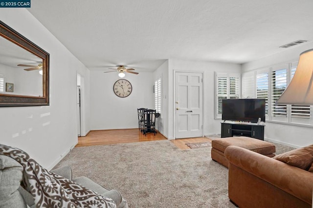 living room featuring light hardwood / wood-style flooring and ceiling fan