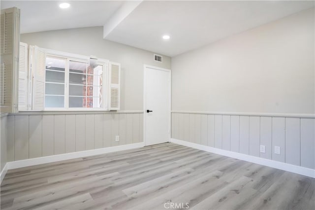 unfurnished room with lofted ceiling and light hardwood / wood-style flooring