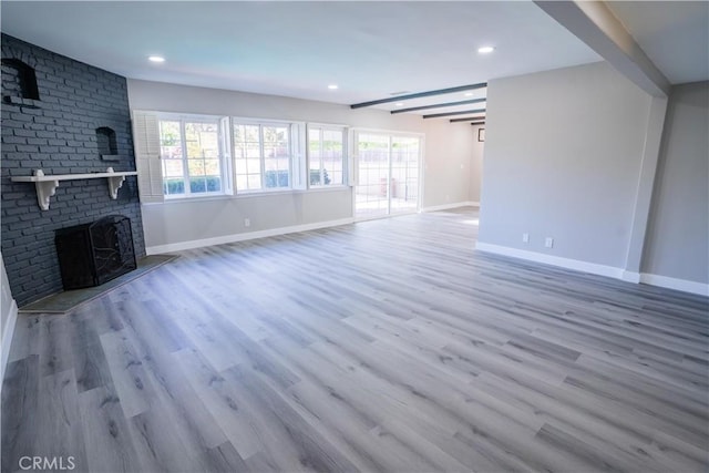 unfurnished living room with plenty of natural light, a fireplace, and hardwood / wood-style floors