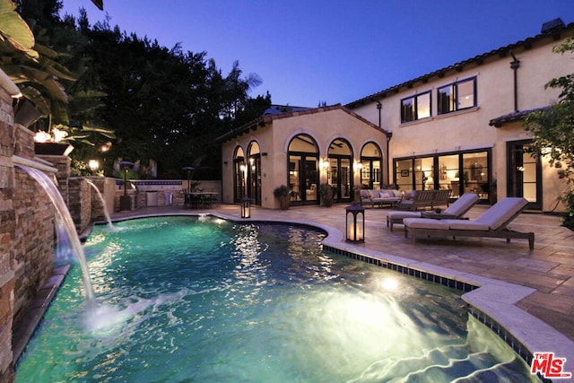 view of swimming pool featuring a patio, an outdoor hangout area, and pool water feature