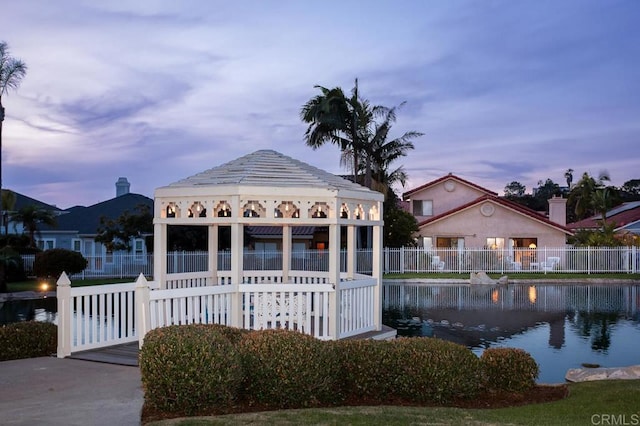 pool at dusk featuring a water view