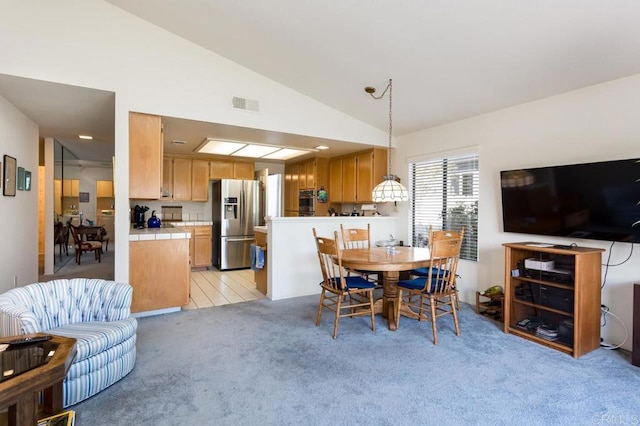 carpeted dining space featuring lofted ceiling