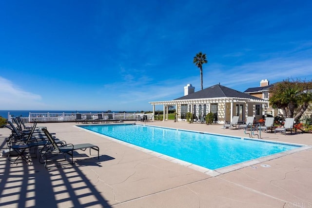 view of swimming pool with a patio and a water view