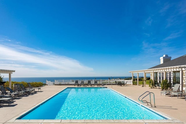 view of swimming pool with a water view and a patio area