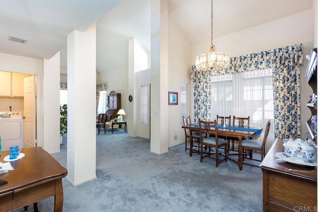 carpeted dining space featuring washer / dryer, high vaulted ceiling, and a notable chandelier