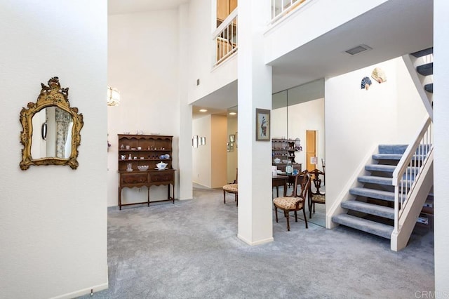 stairway featuring a high ceiling and carpet