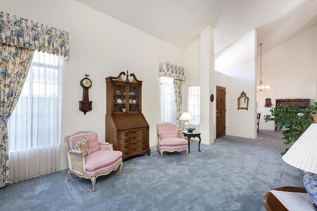 sitting room with an inviting chandelier, carpet flooring, and high vaulted ceiling