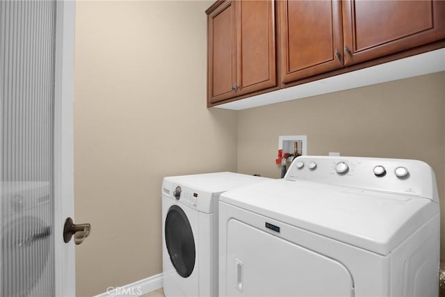 laundry area with cabinets and washing machine and clothes dryer