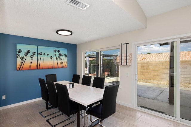 dining area with hardwood / wood-style floors and a textured ceiling