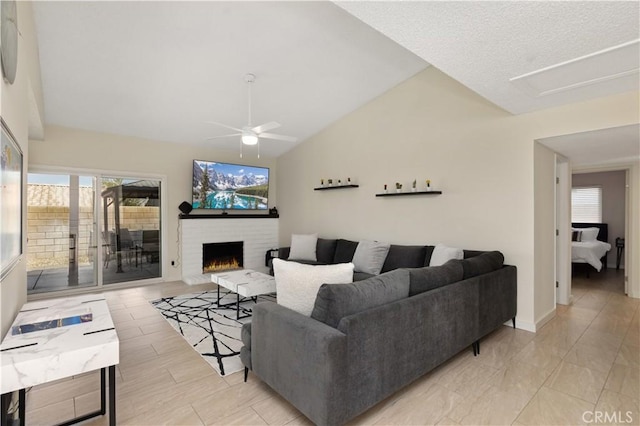 living room with vaulted ceiling, ceiling fan, and a fireplace