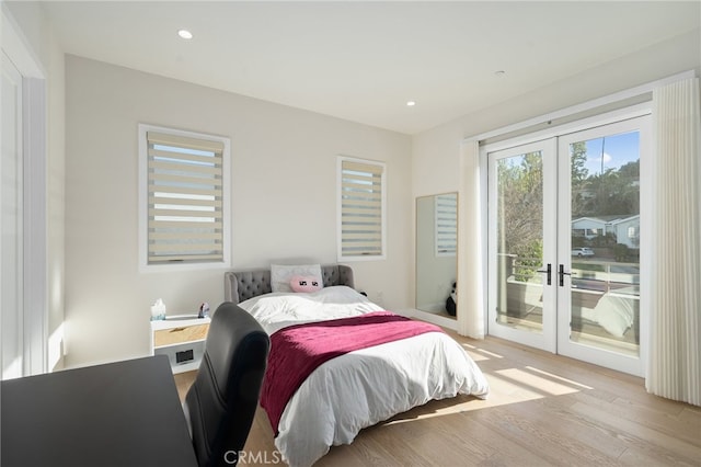 bedroom with access to exterior, light hardwood / wood-style floors, and french doors