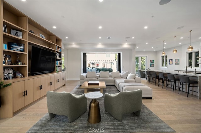 living room with sink and light wood-type flooring