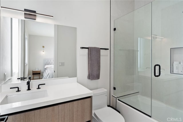 full bathroom featuring vanity, toilet, and combined bath / shower with glass door