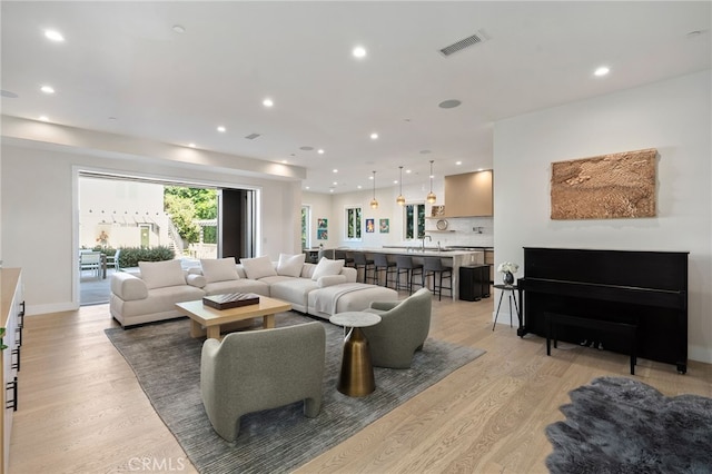 living room with sink and light wood-type flooring