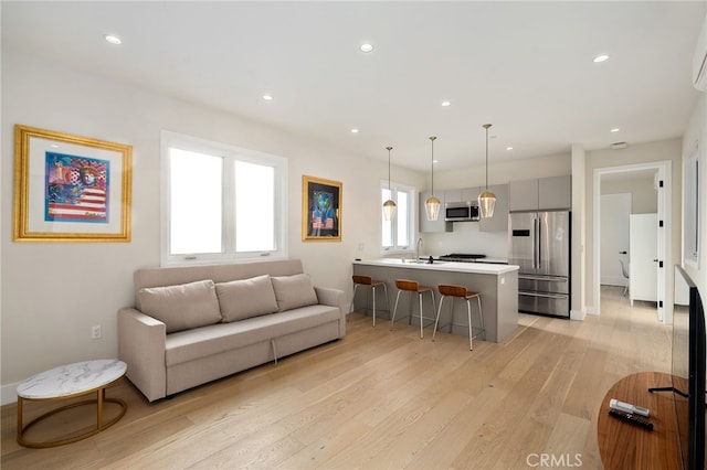 living room with sink and light wood-type flooring