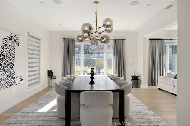 dining room featuring an inviting chandelier and light hardwood / wood-style flooring