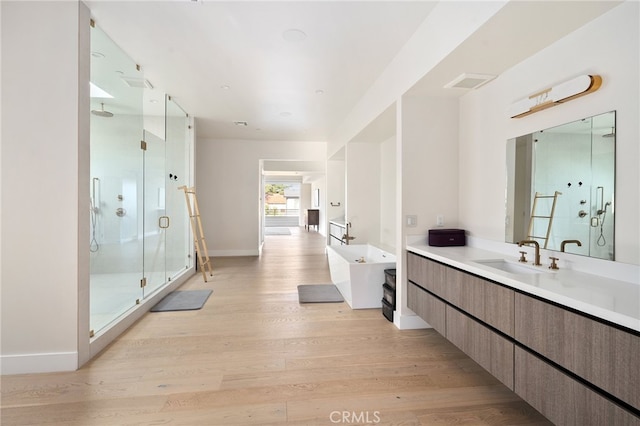 bathroom with shower with separate bathtub, wood-type flooring, and vanity