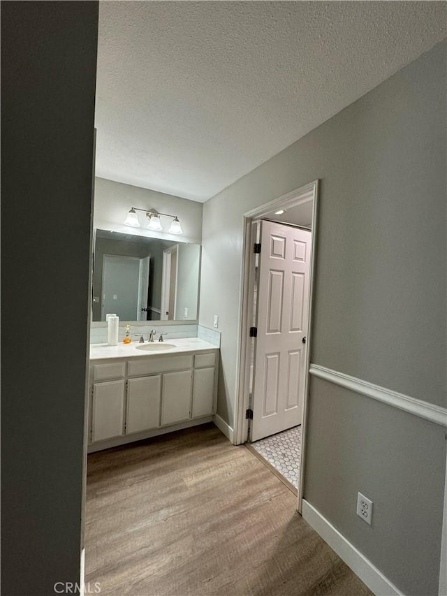 bathroom featuring vanity, wood-type flooring, and a textured ceiling