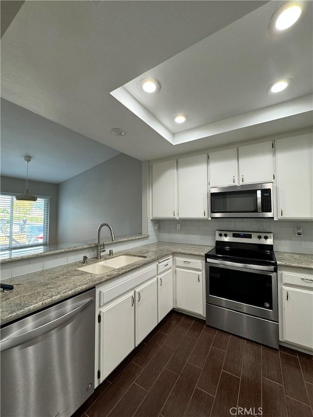 kitchen with stainless steel appliances, sink, and white cabinets