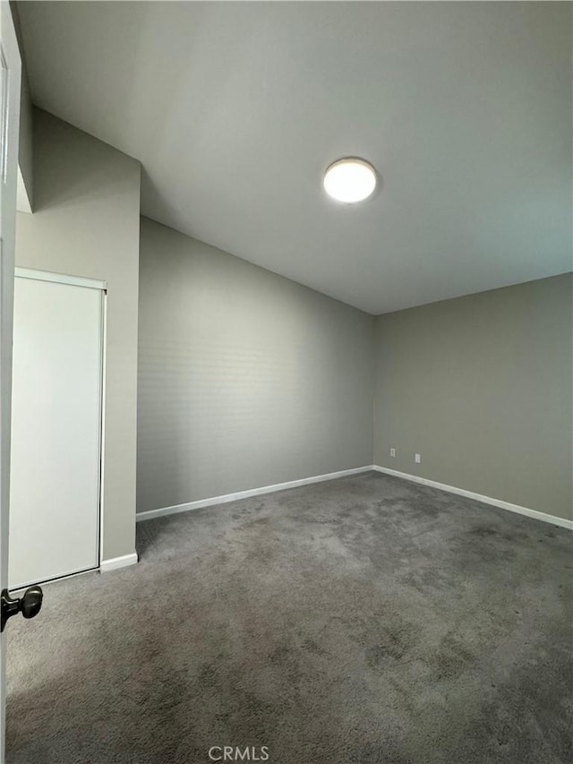 interior space featuring lofted ceiling and dark carpet