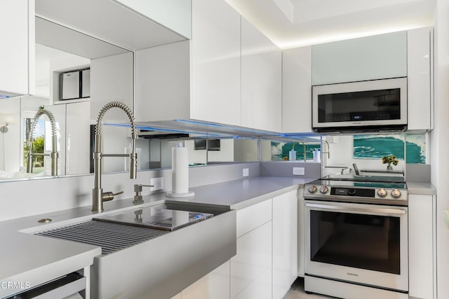 kitchen featuring white cabinetry, sink, and stainless steel electric range