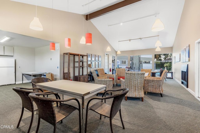 carpeted dining space featuring track lighting, beam ceiling, and high vaulted ceiling