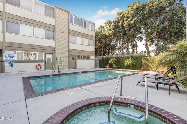 view of swimming pool with a community hot tub