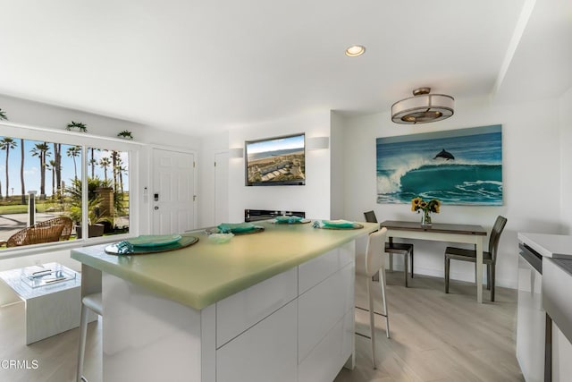 kitchen with modern cabinets, a kitchen bar, recessed lighting, white cabinetry, and dishwasher