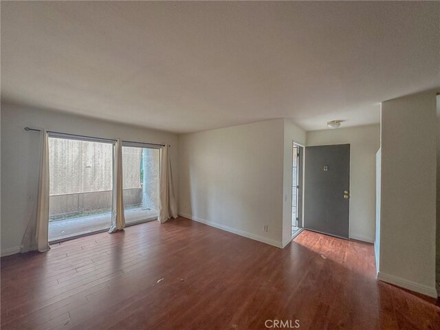 empty room with dark hardwood / wood-style flooring